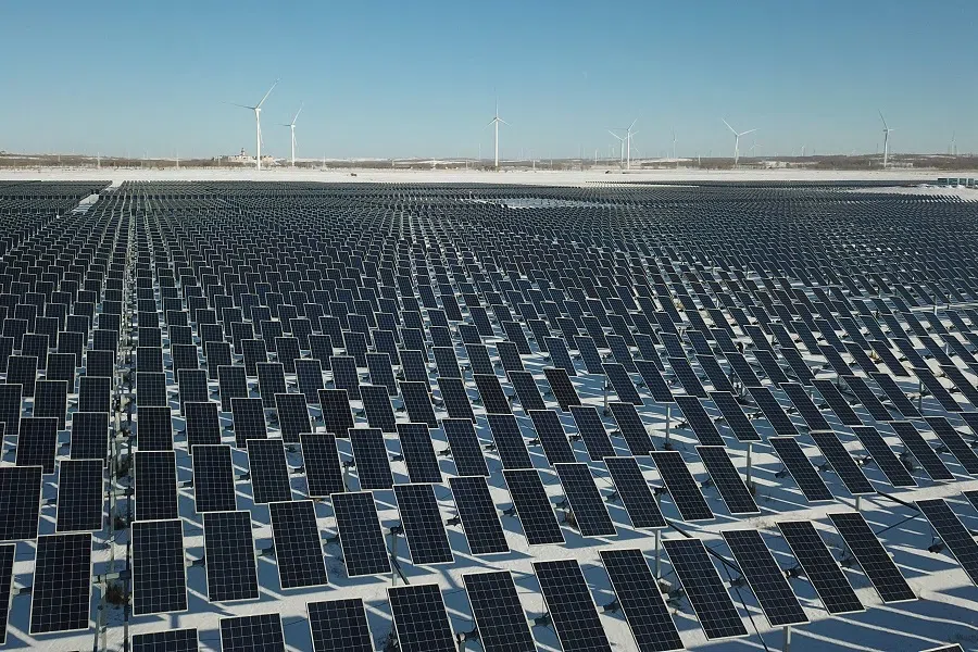 This file photo taken on 12 November 2021 shows solar panels and wind turbines at Zhangbei in Zhangjiakou, Hebei province, China. (Greg Baker/AFP)