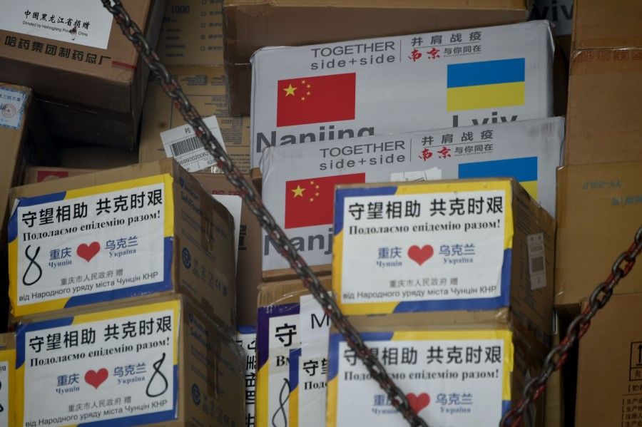 Boxes carrying humanitarian aid from China to help fight against the novel coronavirus, COVID-19, pandemic, are off loaded from a cargo plane at Kiev's airport Boryspil, 24 June 2020. (Sergei Supinsky/AFP)