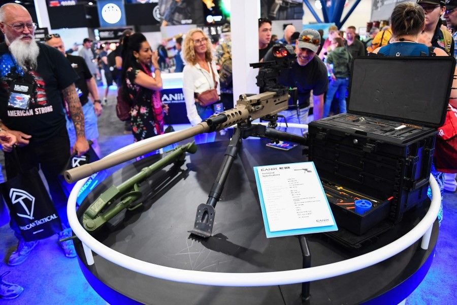 Attendees view a machine gun displayed during the National Rifle Association (NRA) Annual Meeting at the George R. Brown Convention Center, in Houston, Texas on 28 May 2022. America's powerful NRA kicked off a major convention in Houston on Friday, days after the horrific massacre of children at a Texas elementary school, but a string of high-profile no-shows underscored deep unease at the timing of the gun lobby event. (Patrick T. Fallon/AFP)