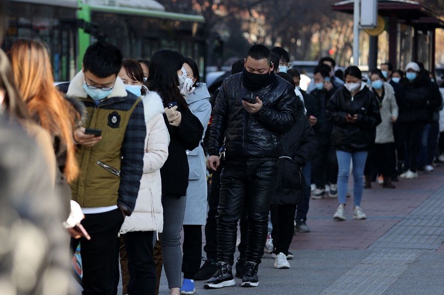 This file photo taken on 21 December 2021 shows people lining up to be tested for the Covid-19 coronavirus in Xi'an, Shaanxi province, China. (AFP)