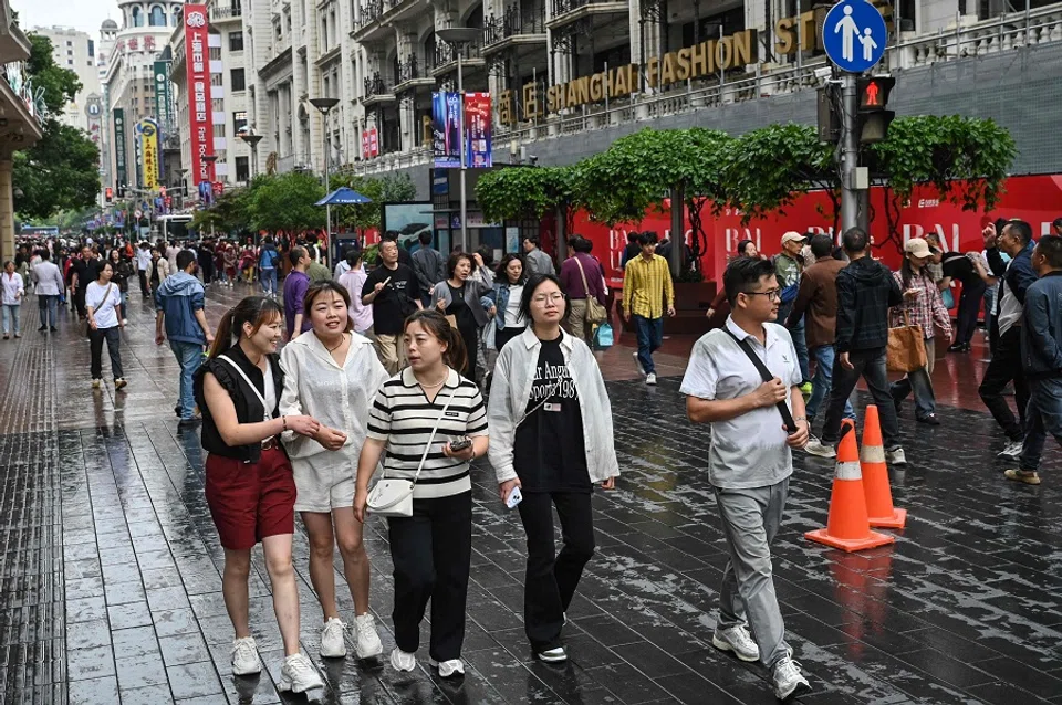 People walk on a pedestrian street in the Huangpu district in Shanghai, China, on 6 June 2024. (Hector Retamal/AFP)