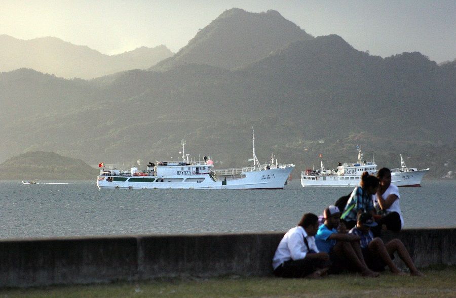 Locals sit on a wall situated on the foreshore of the harbour in the Fiji capital of Suva, 24 August 2014. (Lincoln Feast/File Photo/Reuters)