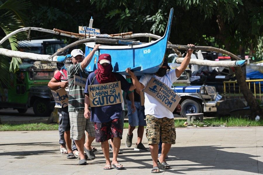 Philippine fishermen, who say they face harassment from Chinese vessels preventing them from entering prime fishing waters in the South China Sea's Scarborough Shoal which is claimed by both countries, demonstrate at a park in Manila on 24 November 2022. (Ted Aljibe/AFP)
