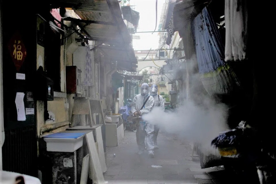 Workers in protective suits disinfect an old residential area under lockdown amid the Covid-19 pandemic, in Shanghai, China, 15 April 2022. (Aly Song/Reuters)