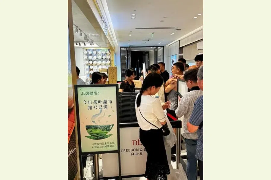 Customers line up to get a number to purchase tea leaves at the Pang Dong Lai Angel City store. 