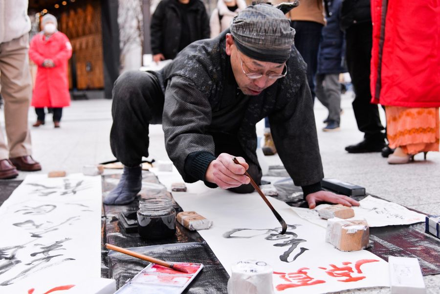 A Japanese calligrapher writes his prayers and blessings (难病退散，万病平愈, roughly, viruses retreat, and illnesses cured) for Wuhan on 9 February 2020, in the streets of Tokyo. (CNS)