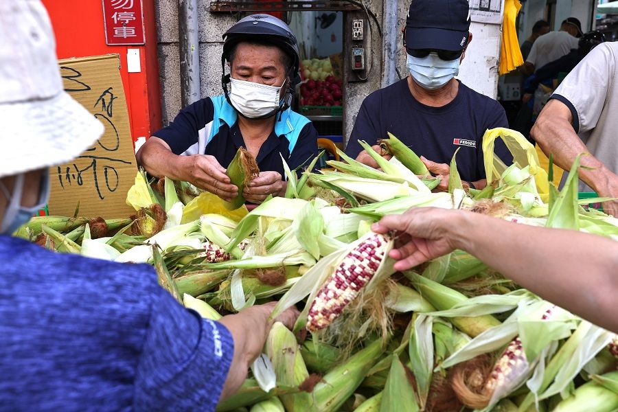 Customers wearing protective face masks shop at a market in Taipei, Taiwan, 16 July 2021. (Ann Wang/Reuters)