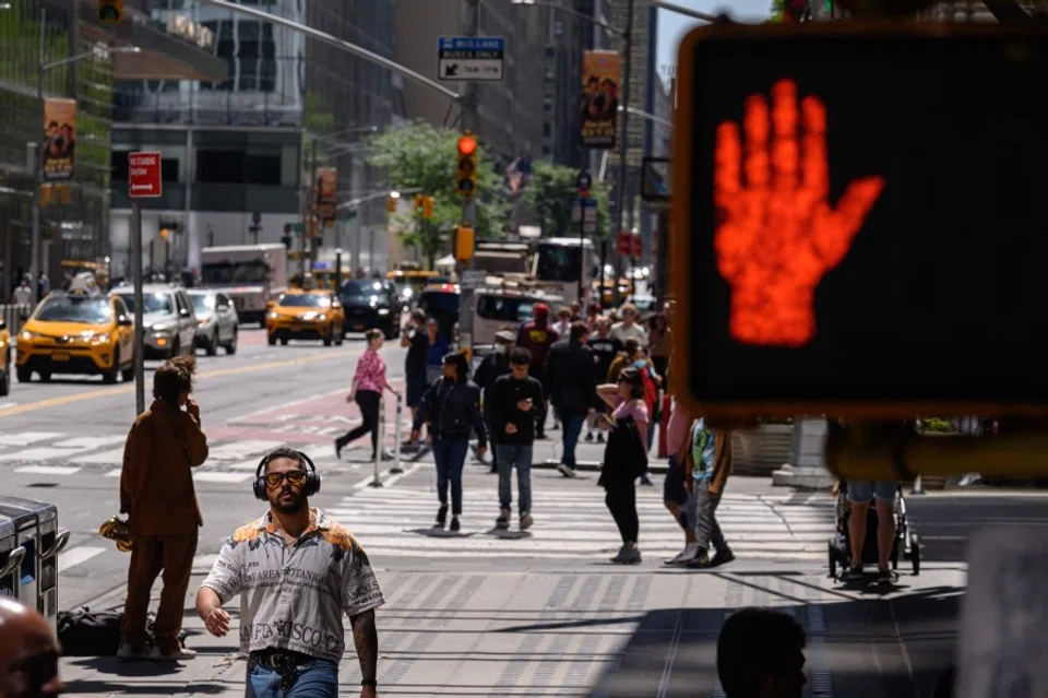 A street sign is displayed before pedestrians on a street in New York on 26 May 2023. (Ed Jones/AFP)