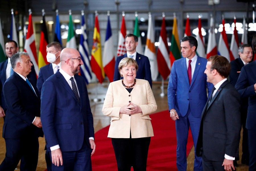 Former German Chancellor Angela Merkel (centre), European Council President Charles Michel (left), French President Emmanuel Macron (right) and members of the European Council pose for a family photo during a face-to-face EU summit in Brussels, Belgium, 21 October 2021. (Johanna Geron/Reuters)