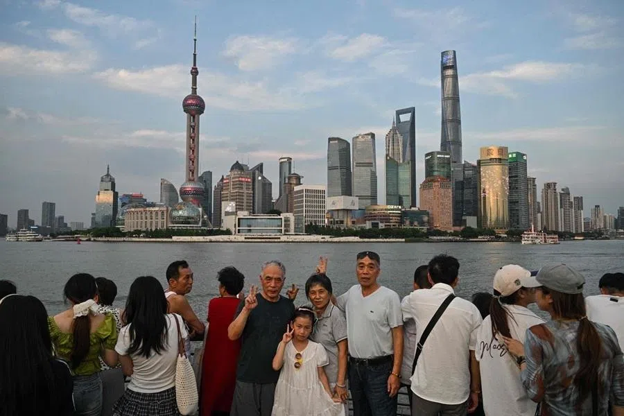 People visit the Bund promenade along the Huangpu river in Shanghai on 17 July 2026.