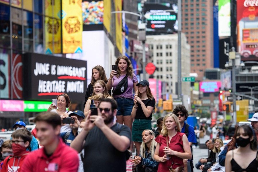 People watch a pop up event in Times Square on 11 June 2021 in New York City. (Angela Weiss/AFP)
