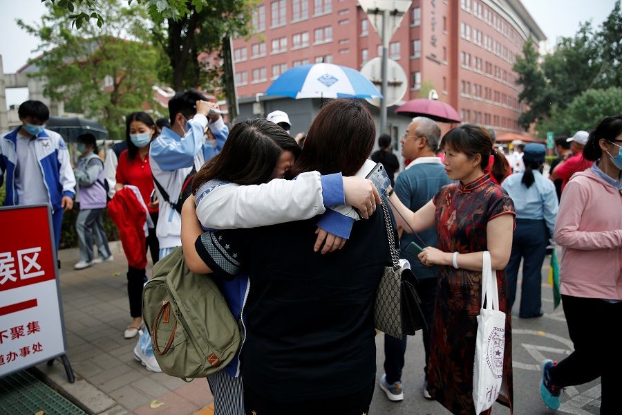A student hugs her family member after an exam in the annual gaokao in Beijing, China, 7 June 2021. (Tingshu Wang/Reuters)