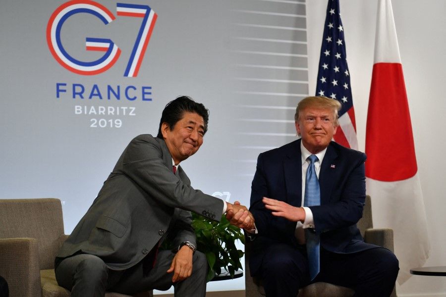 In this file photo taken on 25 August 2019 US President Donald Trump (right) shakes hands with Japan's Prime Minister Shinzo Abe during a bilateral meeting at the Bellevue in Biarritz, south-west France on the second day of the annual G7 Summit. (Nicholas Kamm/AFP)