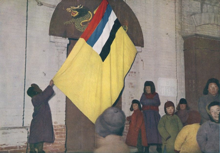 A picture of the Manchukuo flag being raised in northeast China, in publicity material by the Japanese army, 1932.