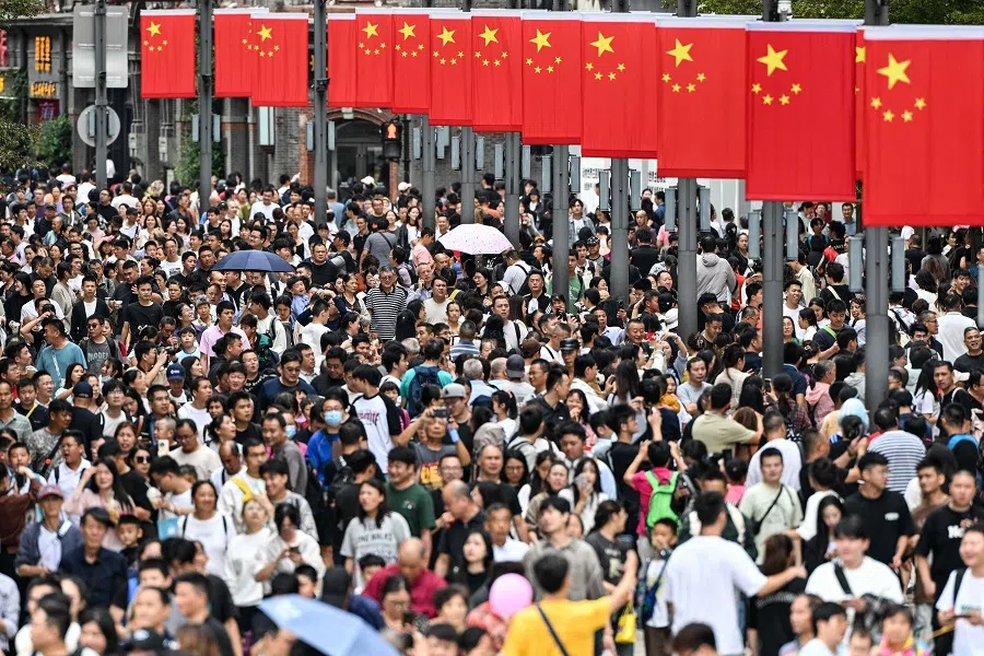 People walk along The Bund on Chinas National Day, marking the 75th anniversary of the founding of the Peoples Republic of China, in Shanghai on 1 October 2024. (Hector Retamal/AFP)