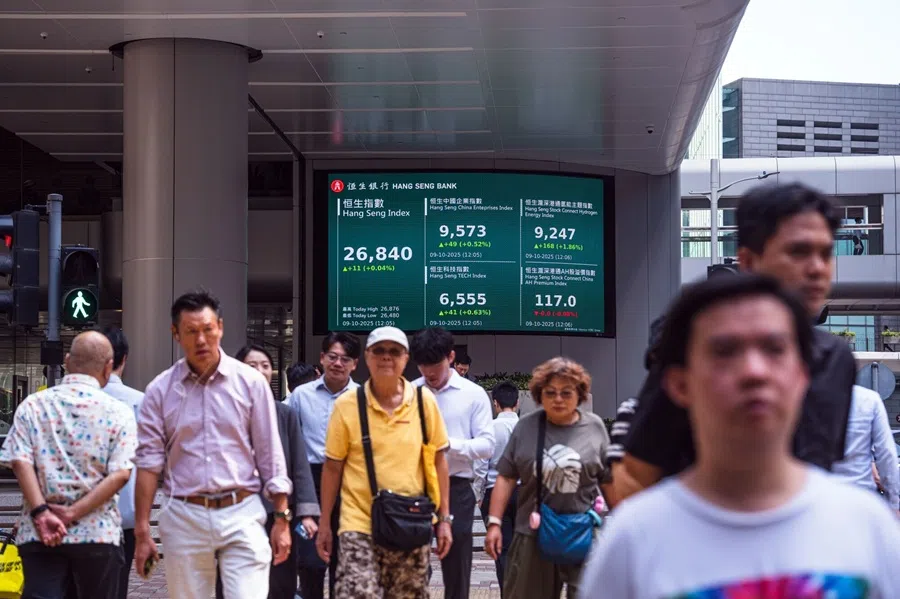 A screen shows a declining Hang Seng Index, left, and other indices at the Hang Seng Bank headquarters at the Hang Seng Bank Ltd. headquarters in Hong Kong, China, 9 October 2025.  (Lam Yik/Bloomberg)