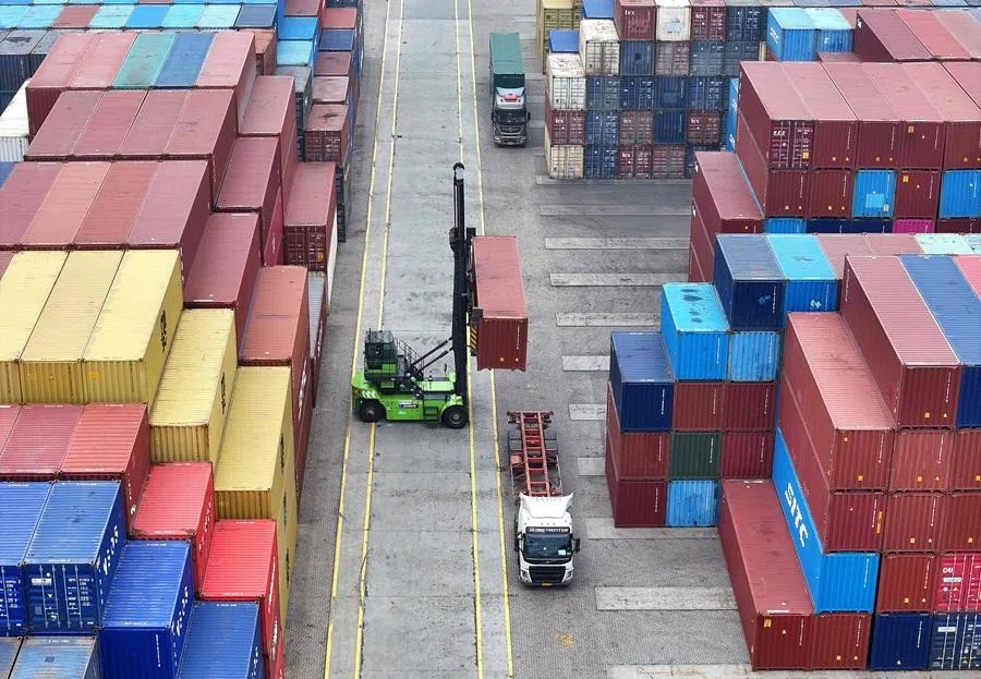 An operator uses a heavy equipment to move containers at the container terminal in Lianyungang, Jiangsu province, China, on 24 March 2026.