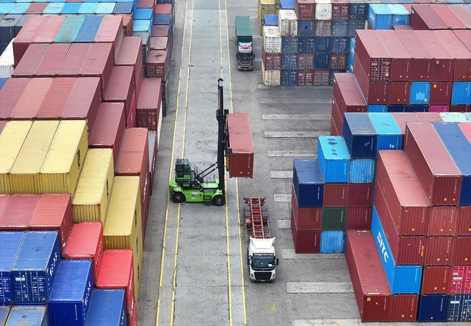 An operator uses a heavy equipment to move containers at the container terminal in Lianyungang, Jiangsu province, China, on 24 March 2026. (CN-STR/AFP)