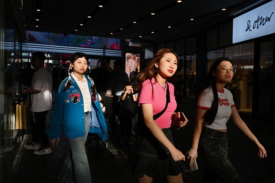 People walk through a shopping mall in Beijing, China, on 30 April 2023. (Greg Baker/AFP)