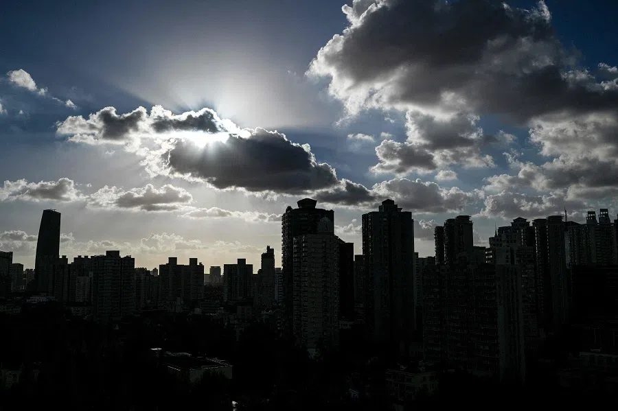 This file photo taken on 17 September 2024 shows buildings silhouetted as clouds drift past the sun in Shanghai. (Hector Retamal/AFP)