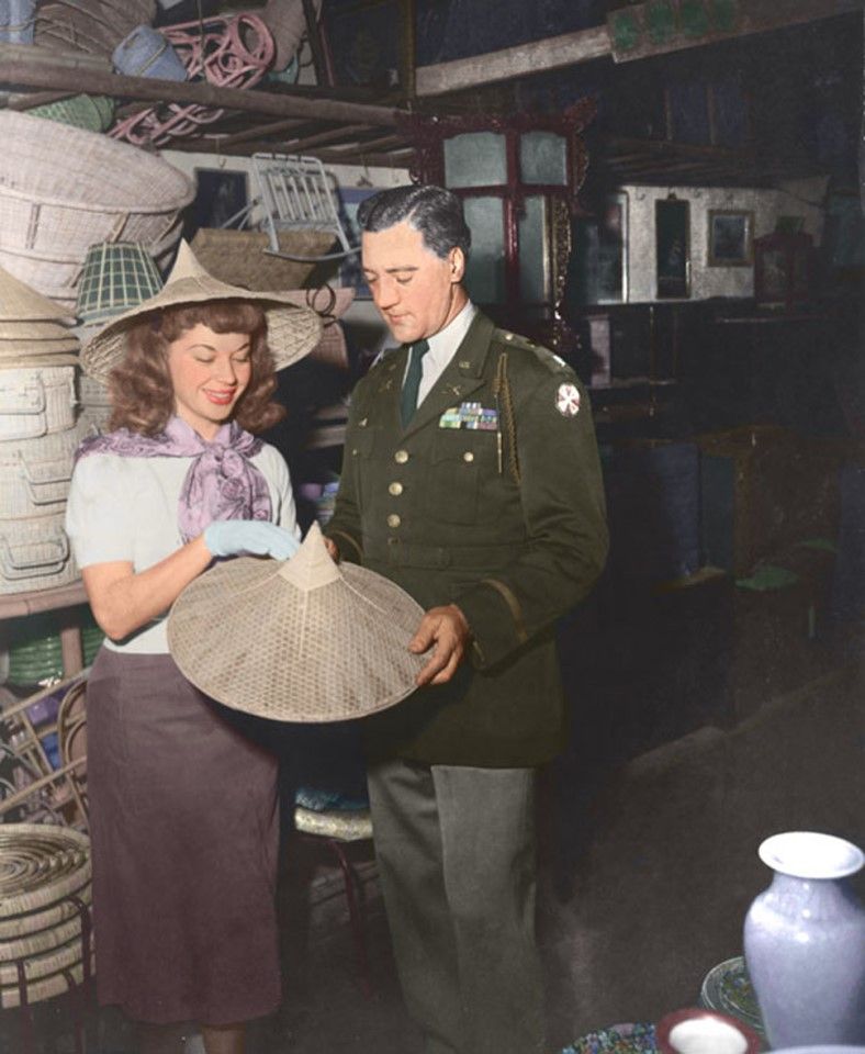A member of the US Armed Forces Entertainment visiting a Taiwanese local crafts shop after a performance, accompanied by a US officer, 1950s.