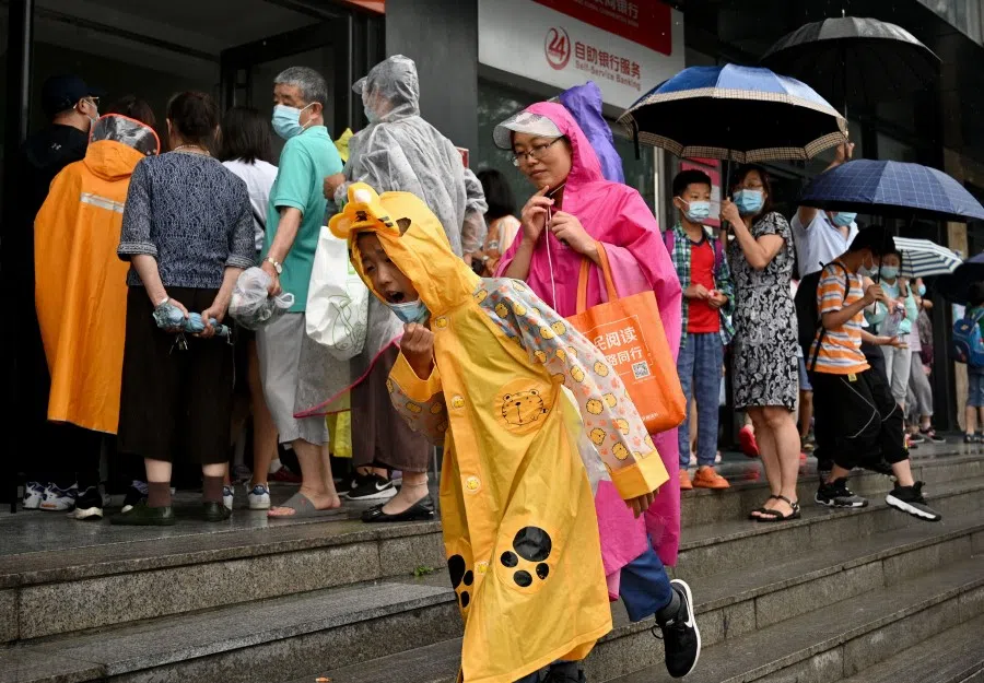 This picture taken on 29 July 2021, shows students and parents walking after attending a private after-school education in Haidan district of Beijing. In Beijing's Haidian district where homes go for millions and competition is cutthroat for a spot in top schools, parents say sudden curbs on private after-school education are misplaced while the competition facing their kids is so tough. (Noel Celis/AFP)