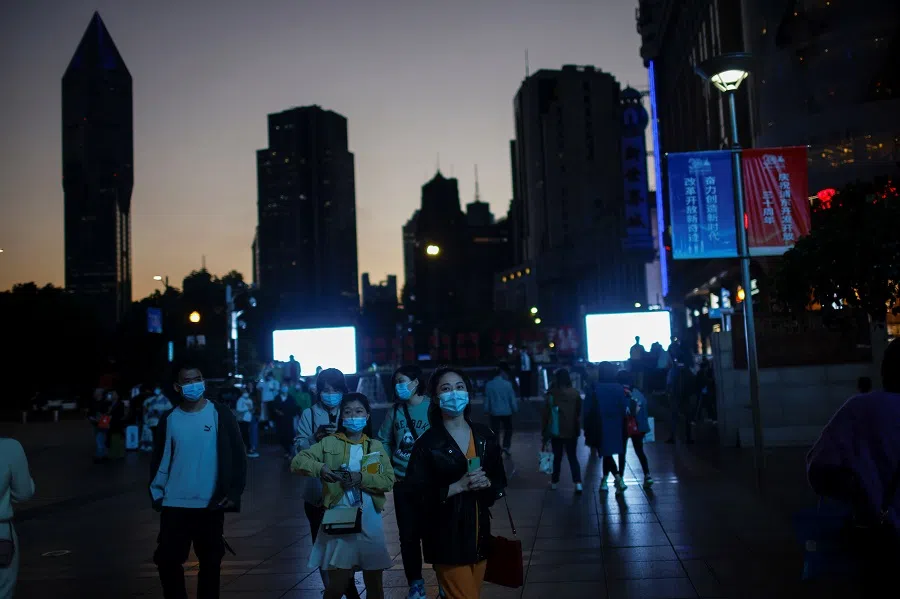 People wearing face masks walk on a street in Shanghai, China, 13 November 2020. (Aly Song/Reuters)