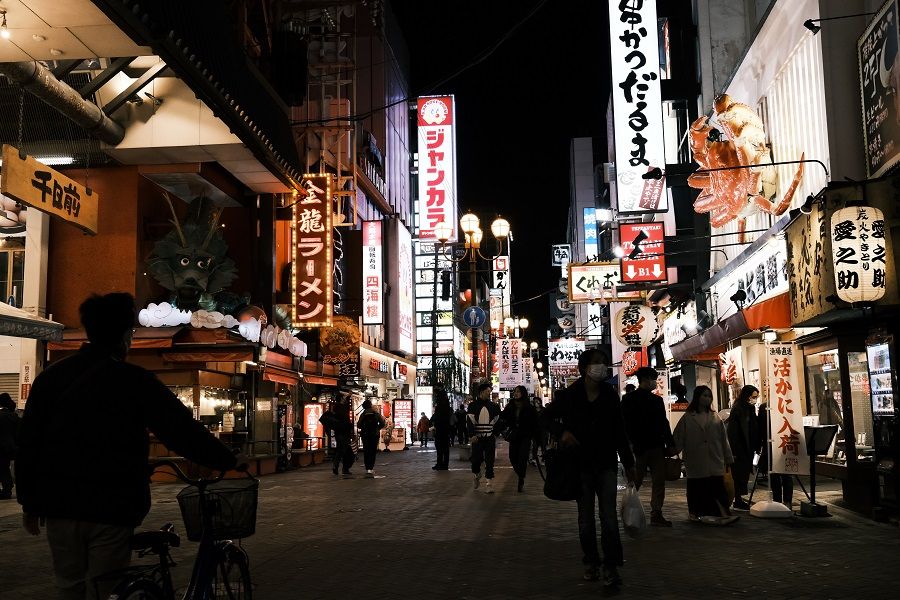 People walk through a street in the Namba district of Osaka, Japan, on 29 November 2020. (Soichiro Koriyama/Bloomberg)
