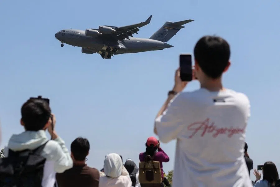 People use their phones as a US Air Force C-17A Globemaster III lands at Beijing Capital International Airport, ahead of US President Donald Trump's state visit to China, in Beijing, China, on 11 May 2026.