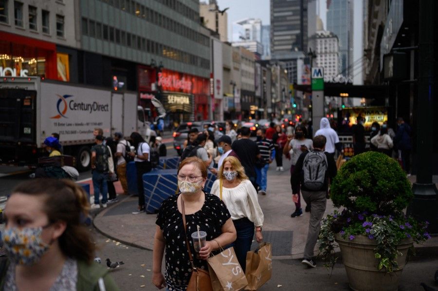 Pedestrians wearing face masks pass along a street in Manhattan, New York on 3 June 2021. (Ed Jones/AFP)