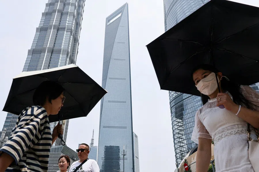 People walk near the Shanghai World Financial Center in the Lujiazui financial district in Shanghai, China, on 18 July 2025.