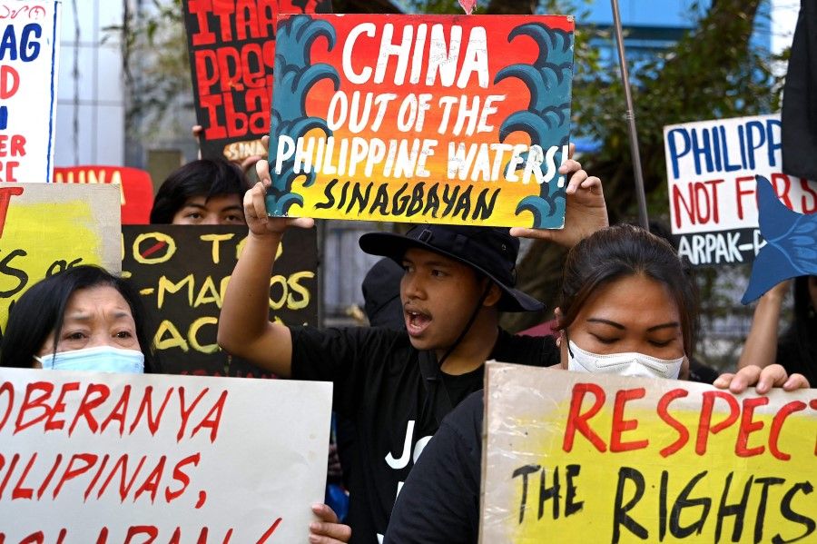 Protesters raise their placards as they stage a demonstration to condemn China's aggression in the disputed South China Sea, in front of the Chinese consulate in Makati, Metro Manila, on 6 February 2024. (Jam Sta Rosa/AFP)