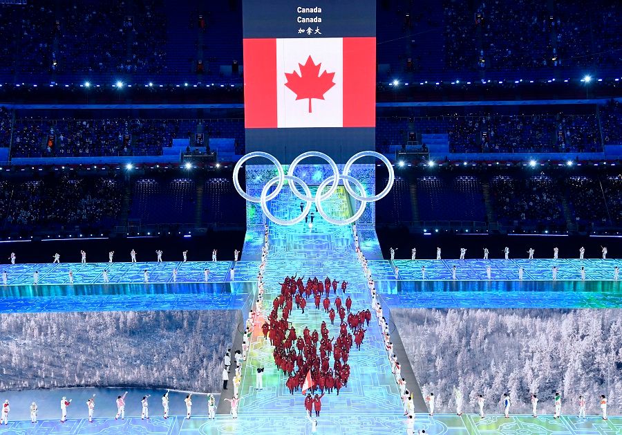 Performers stand as flagbearers Marie-Philip Poulin of Canada and Charles Hamelin of Canada walk during the opening ceremony at the National Stadium, Beijing, China, 4 February 2022. (Toby Melville/Reuters)