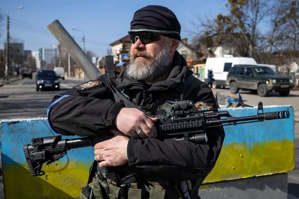 A volunteer takes position at a checkpoint in a district in Kyiv, Ukraine, on 20 March 2022. (Fadel Senna/AFP)