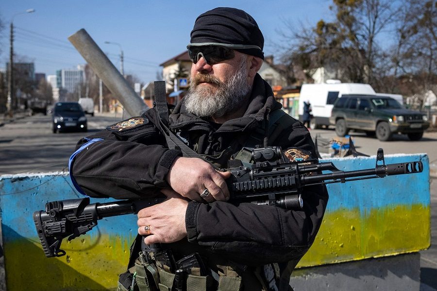 A volunteer takes position at a checkpoint in a district in Kyiv, Ukraine, on 20 March 2022. (Fadel Senna/AFP)