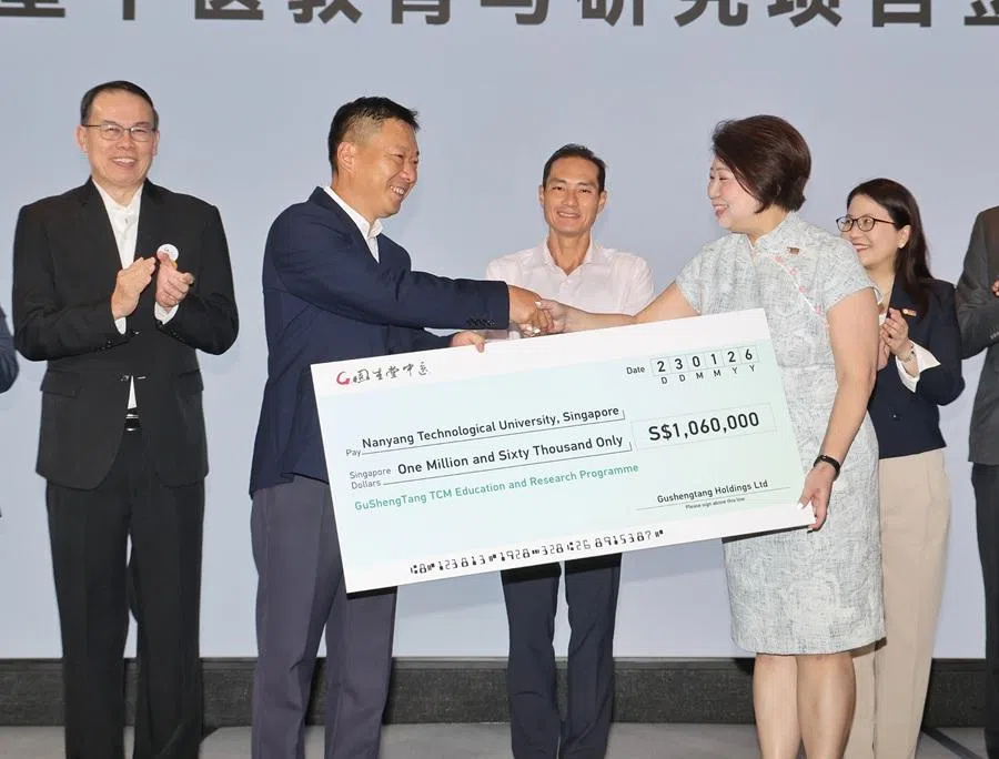Gu Sheng Tang TCM chairman Tu Zhiliang (front, left) presents the S$1.06 million donation to Tan Aik Na, Senior Vice President of Administration, Nanyang Technological University (NTU). Back row (left to right): Teo Ho Pin, Chairperson, Traditional Chinese Medicine Practitioners Board; Tan Kiat How, Senior Minister of State, Ministry of Digital Development and Information & Ministry of Health; and See E’Jin, Chief Development Officer, NTU. (Dennis Thong/SPH Media)