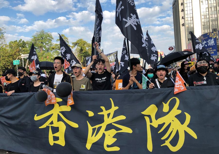 Protesters hold banners and flags in support of Hong Kong's pro-democracy protests, during a rally against main opposition Kuomintang party's presidential candidate Han Kuo-yu, in Kaohsiung, Taiwan on 21 December 2019. (Yimou Lee/Reuters)
