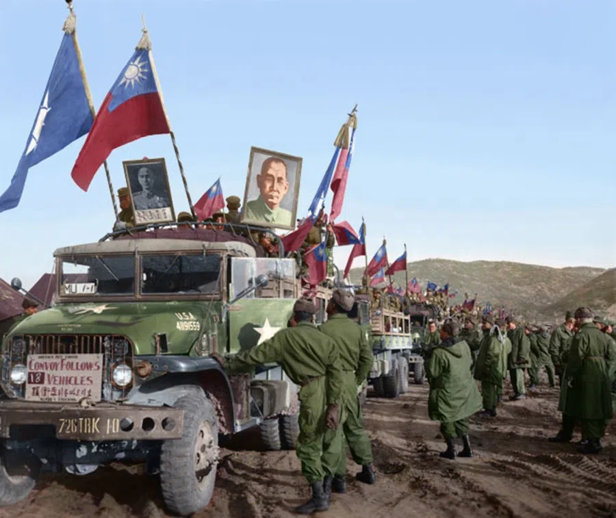 UNC soldiers escorting volunteer army POWs heading off to board landing ship tanks bound for Taiwan, 1954. The KMT government called them anti-communist heroes (反共义士). Here, they are holding up the Republic of China flag, and portraits of Sun Yat-sen and Chiang Kai-shek.