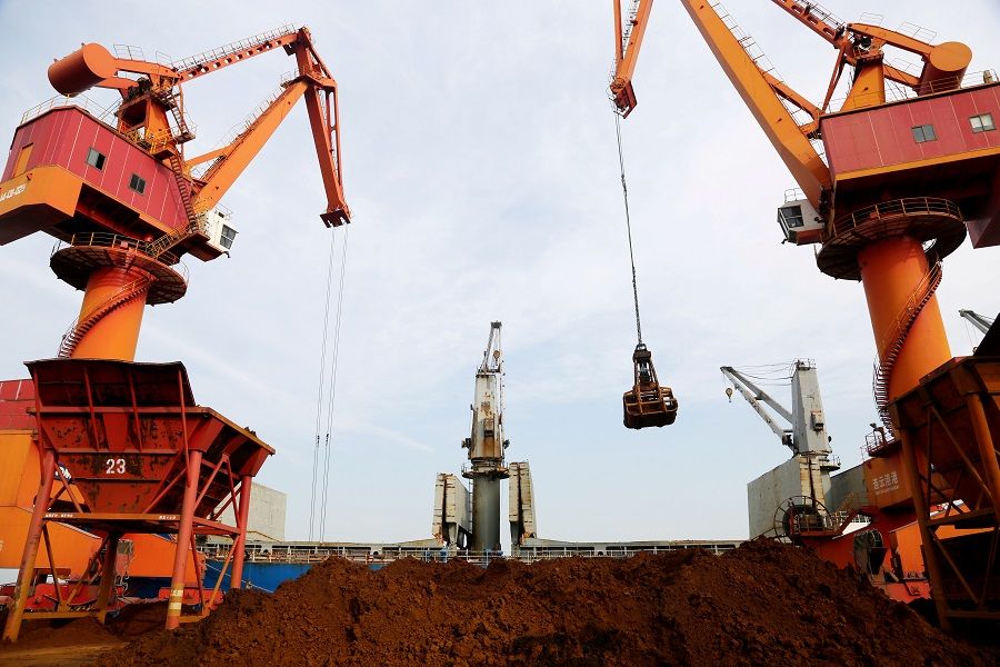 Cranes unload imported iron ore from a cargo vessel at a port in Lianyungang, Jiangsu province, China, 27 October 2019. (Stringer/File Photo/Reuters)