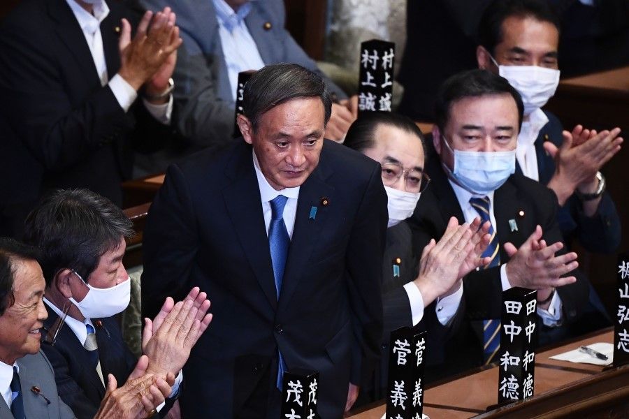 Newly elected leader of Japan's Liberal Democratic Party (LDP) Yoshihide Suga (C) is applauded after he was elected as Japan's prime minister by the lower house of parliament in Tokyo on 16 September 2020. (Charly Triballeau/AFP)