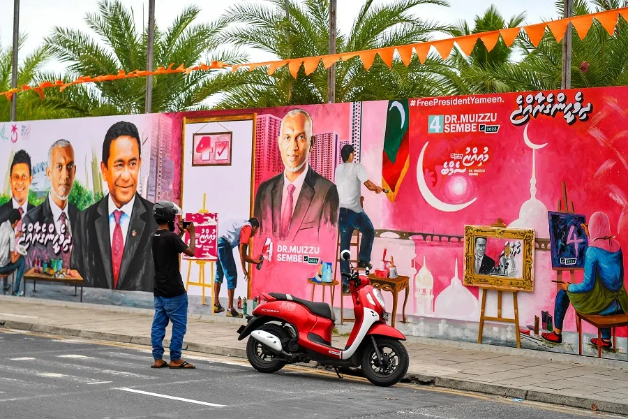 A commuter takes pictures with his mobile phone of a decorated wall along a street ahead of the country's presidential election, in Male, Maldives, on 6 September 2023. (Mohamed Afrah/AFP)