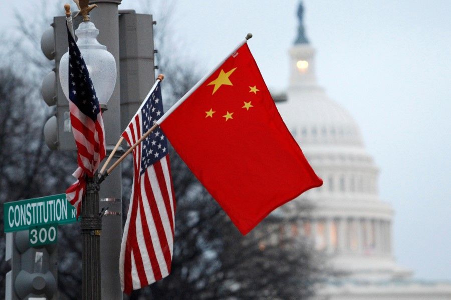 This file photo shows the People's Republic of China flag and the U.S. flag fly on a lamp post along Pennsylvania Avenue near the U.S. Capitol in Washington, 18 January 2011. (Hyungwon Kang/Reuters)