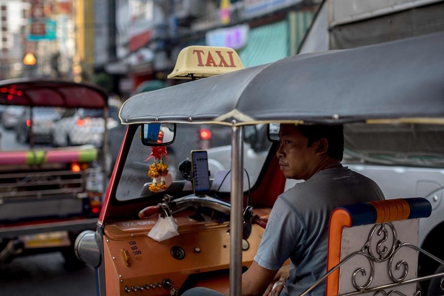 A tuk-tuk driver looks out from his vehicle as he waits for customers in the Chinatown area of Bangkok, Thailand, on 19 October 2022. (Jack Taylor/AFP)