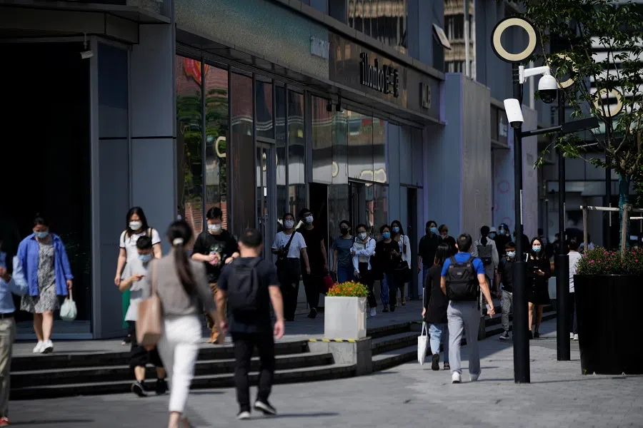 People wearing protective face masks walk on a street during morning rush hour, after the lockdown placed to curb the Covid-19 outbreak was lifted in Shanghai, China, 6 June 2022. (Aly Song/Reuters)