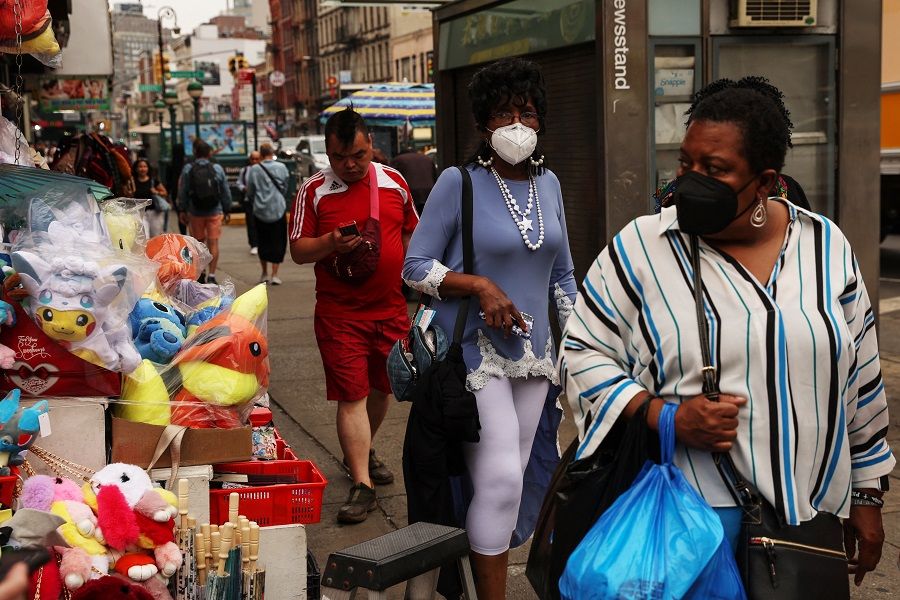 People walk down Canal Street in the Chinatown neighbourhood of New York City, 12 June 2023. (Shannon Stapleton/Reuters)