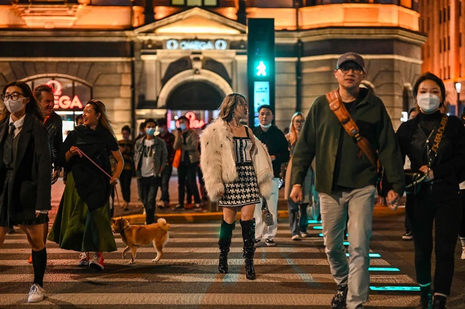 People cross a street on The Bund in Shanghai, China, on 12 October 2022. (Hector Retamal/AFP)