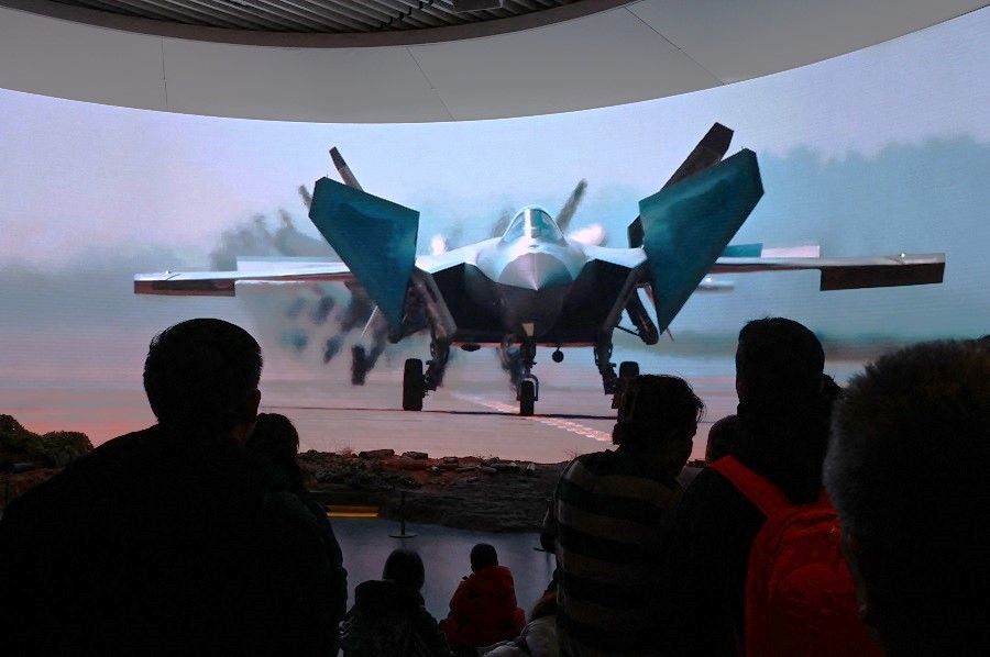 People watch a video about China's military advancements at the Military Museum in Beijing, China, on 3 March 2024. (Greg Baker/AFP)