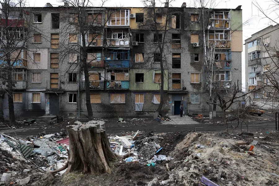 A local resident stands in the doorway of a building partially destroyed by Russian shelling in the Ukrainian town of Kupiansk, Kharkiv region on 7 March 2023. (Anatolii Stepanov/AFP)