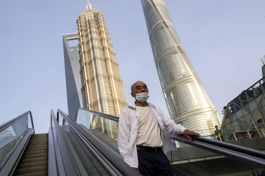 A pedestrian rides an escalator in Pudong's Lujiazui Financial District in Shanghai, China, on 2 June 2023. (Raul Ariano/Bloomberg)