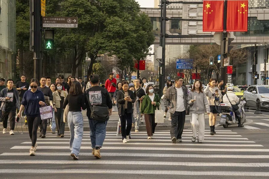 Pedestrians cross a road in Shanghai, China, on 2 March 2025. (Raul Ariano/Bloomberg)